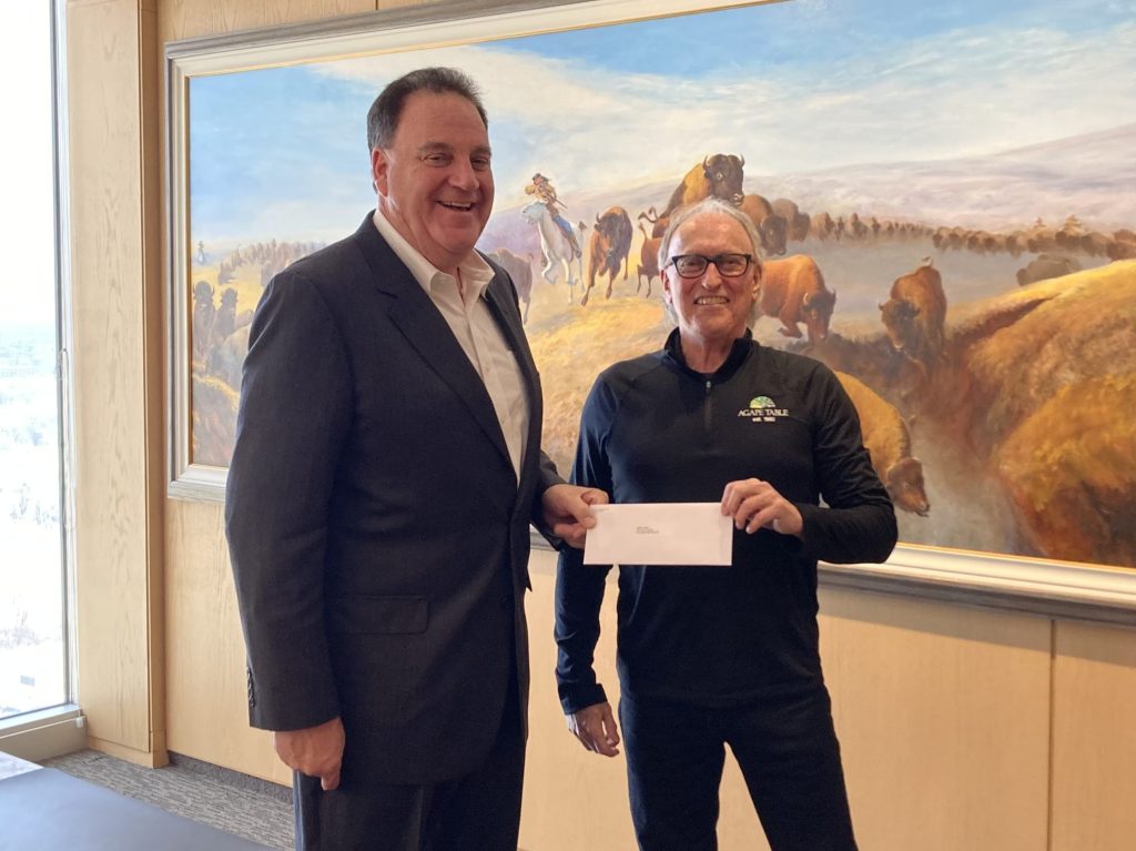 Andrew Paterson presenting a $75,000 donation to Jim Steep of Agape Table